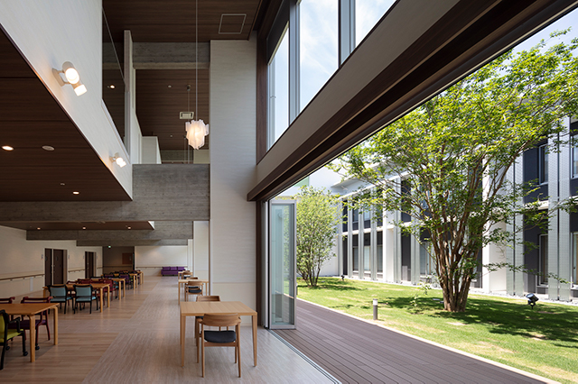 介護⽼⼈保健施設 葵の園 松⼾東|中庭とロビーの一体感を向上